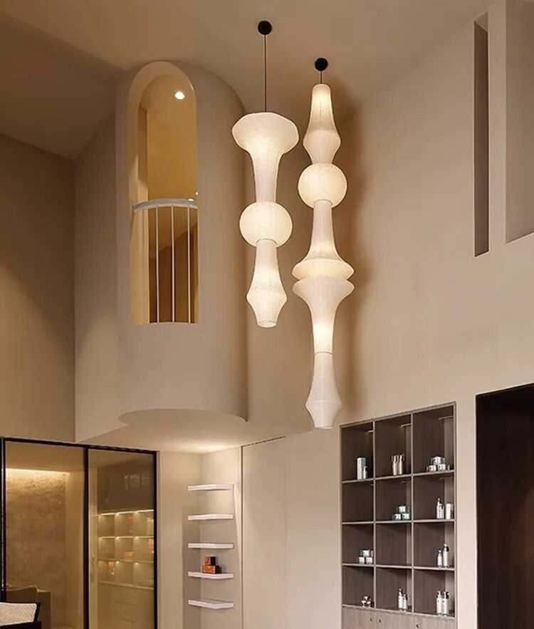 Elegant Japanese paper lantern pendant lights hanging in a high-ceiling modern interior. Large rice paper lamps with Noguchi-inspired designs, adding warmth and sophistication to a minimalist space. Ideal for creating a soft ambient glow in high-ceiling rooms.