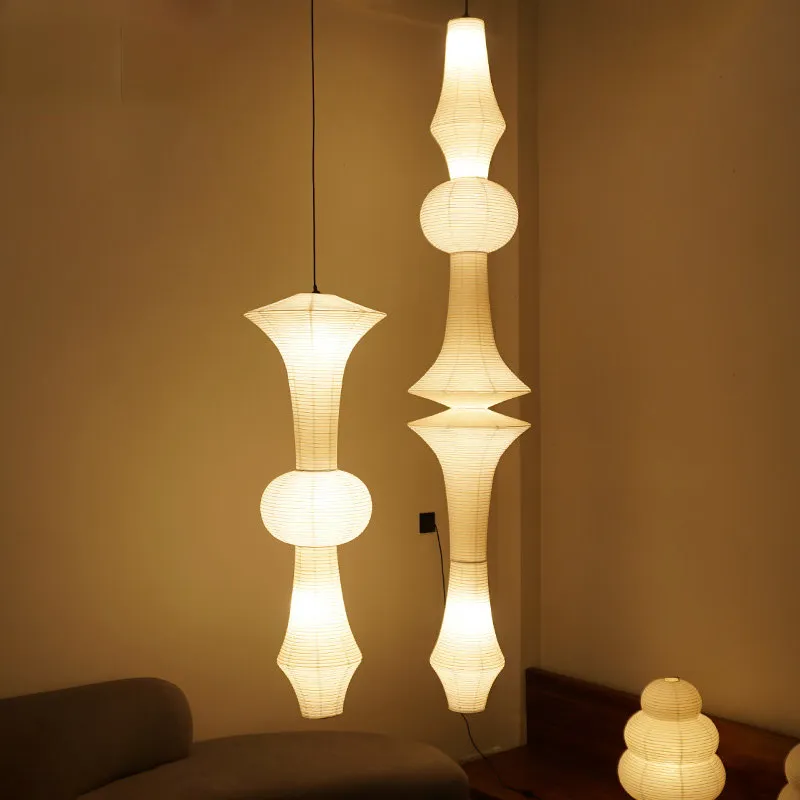 Warmly lit Japanese paper lantern pendant lights with Noguchi-inspired designs. Large rice paper lamps illuminating a modern interior, showcasing a cozy and elegant aesthetic. Ideal for creating a serene ambiance with a soft, warm glow.