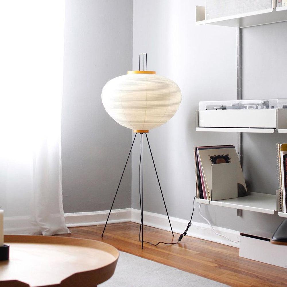 Noguchi Akari floor lamp with a handmade washi paper shade and slim tripod base, adding soft lighting to modern minimalist interiors.